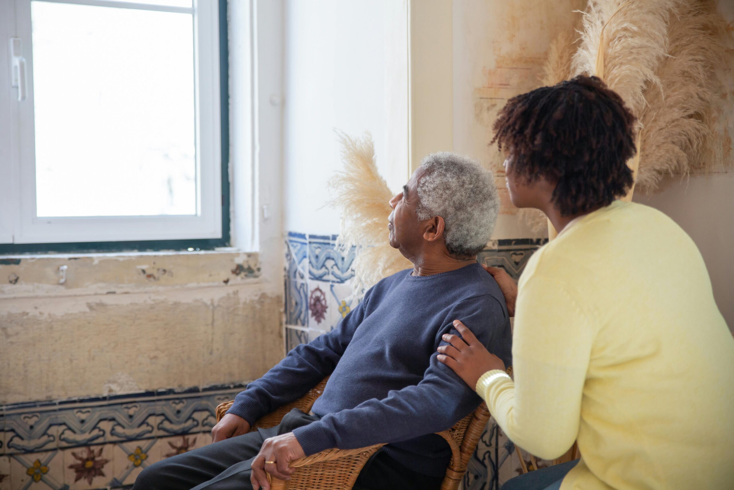 Elderly Man and Woman Looking Outside Window